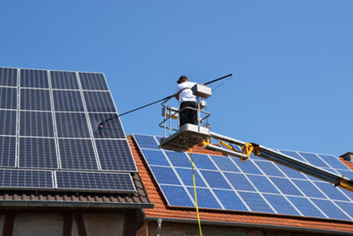 Mit einem Kran wird die Fotovoltaikanlage gereinigt